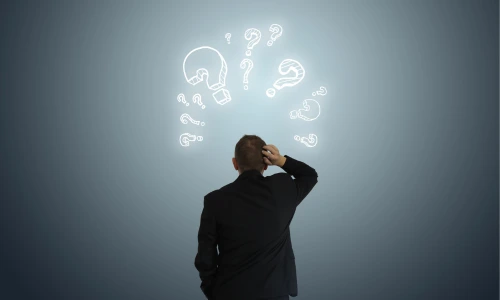 A man from behind, scratching his head, with several glowing white question marks floating above his head against a blue-grey background.