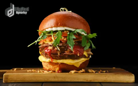 A black Jovance mascara tube with the wand pulled out and resting on the side, displayed on a white cylindrical pedestal against a white background, with the Digital Sparky logo.