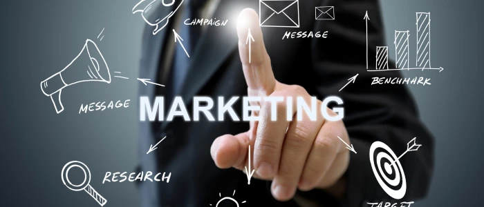 A hand touching a holographic display with "MARKETING" at the center, surrounded by icons like a megaphone, research, target, benchmark, message, and campaign.
